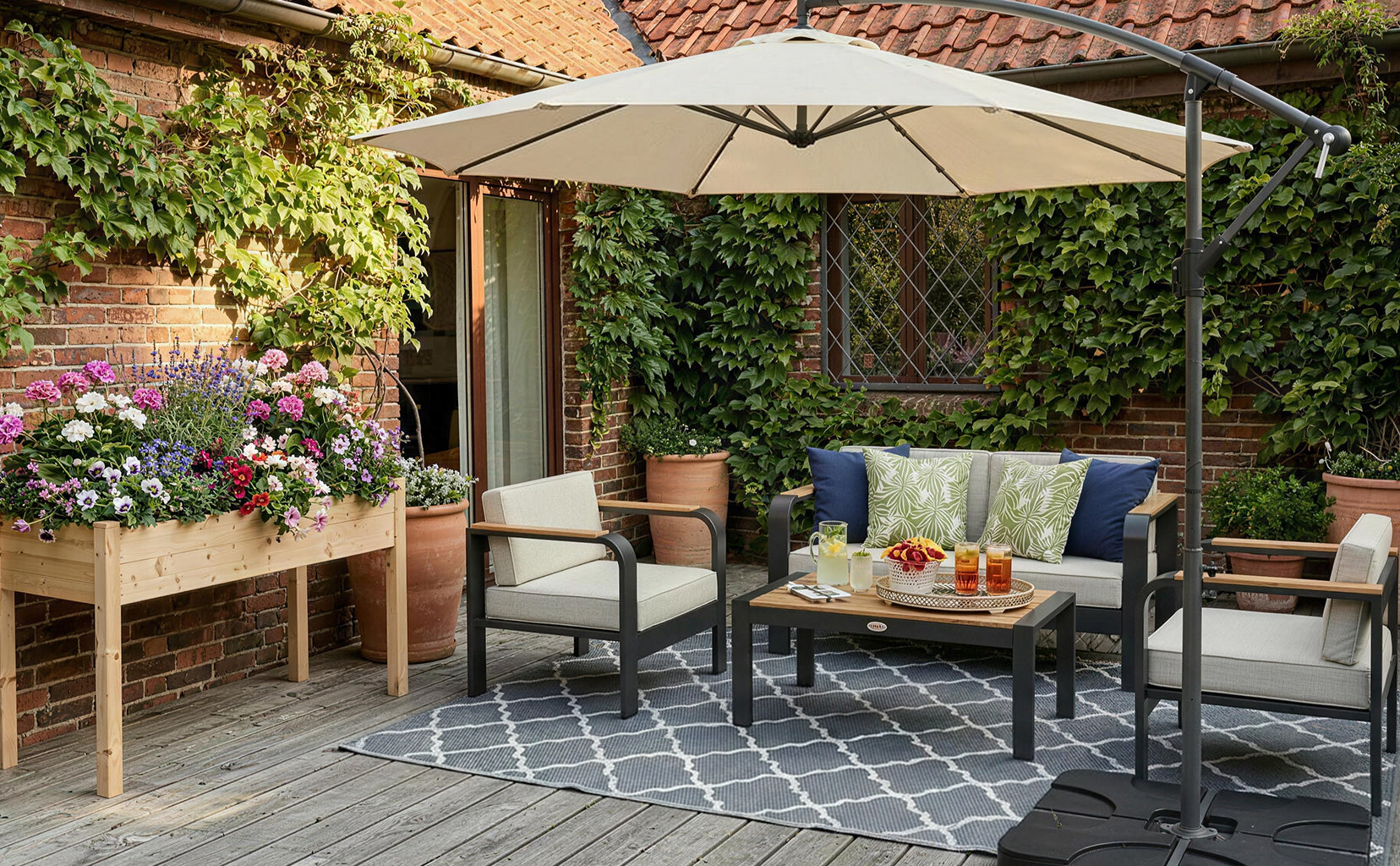 Outdoor patio with furniture, umbrella, and decorative elements on a wooden deck.